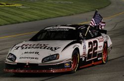 Rather than a burnout, Brad Keselowski celebrates his second win of the season hoisting an American flag during a victory lap at Richmond International Raceway. Credit: Al Bello/Getty Images